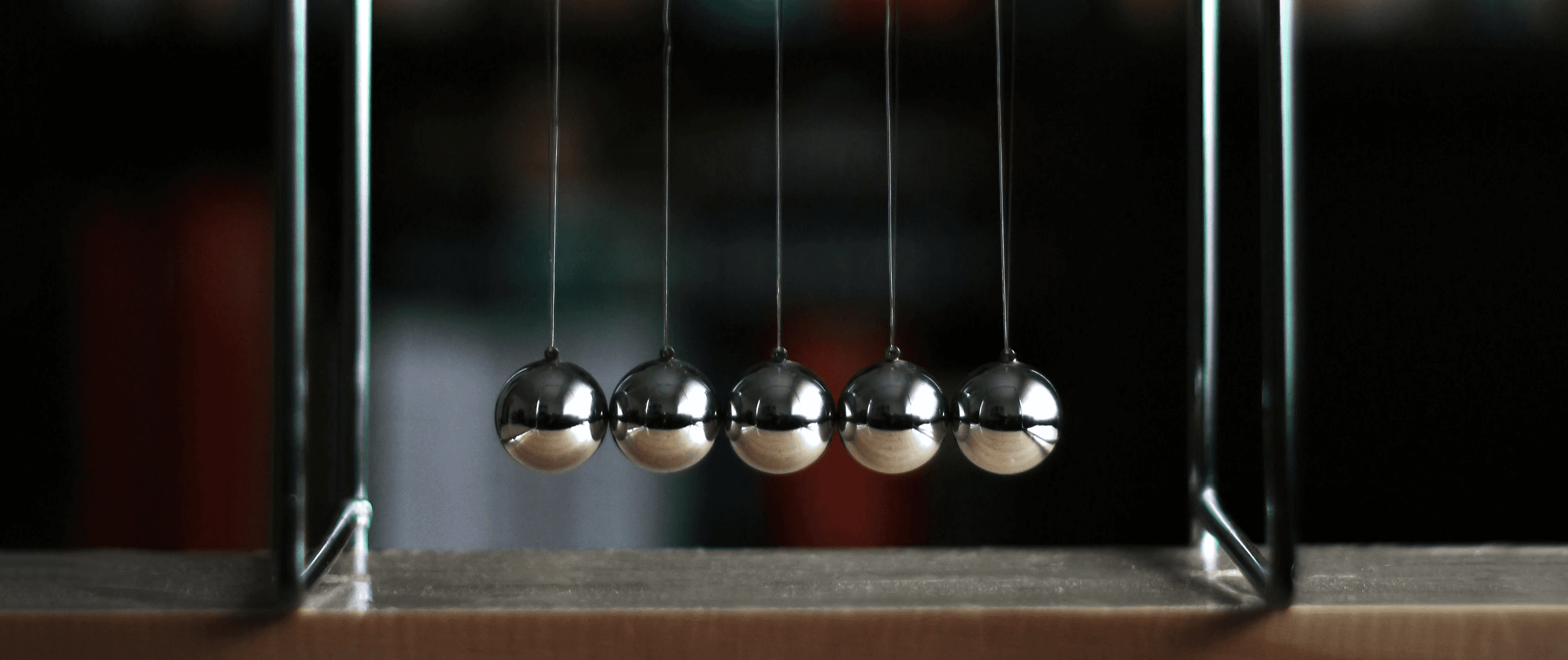 a metal newton scale with three balls on it