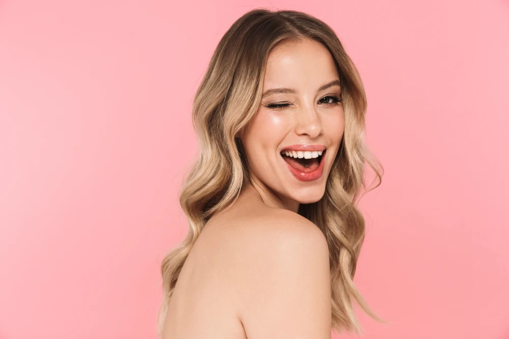 Woman with glowing skin smiling confidently after chemical peels.