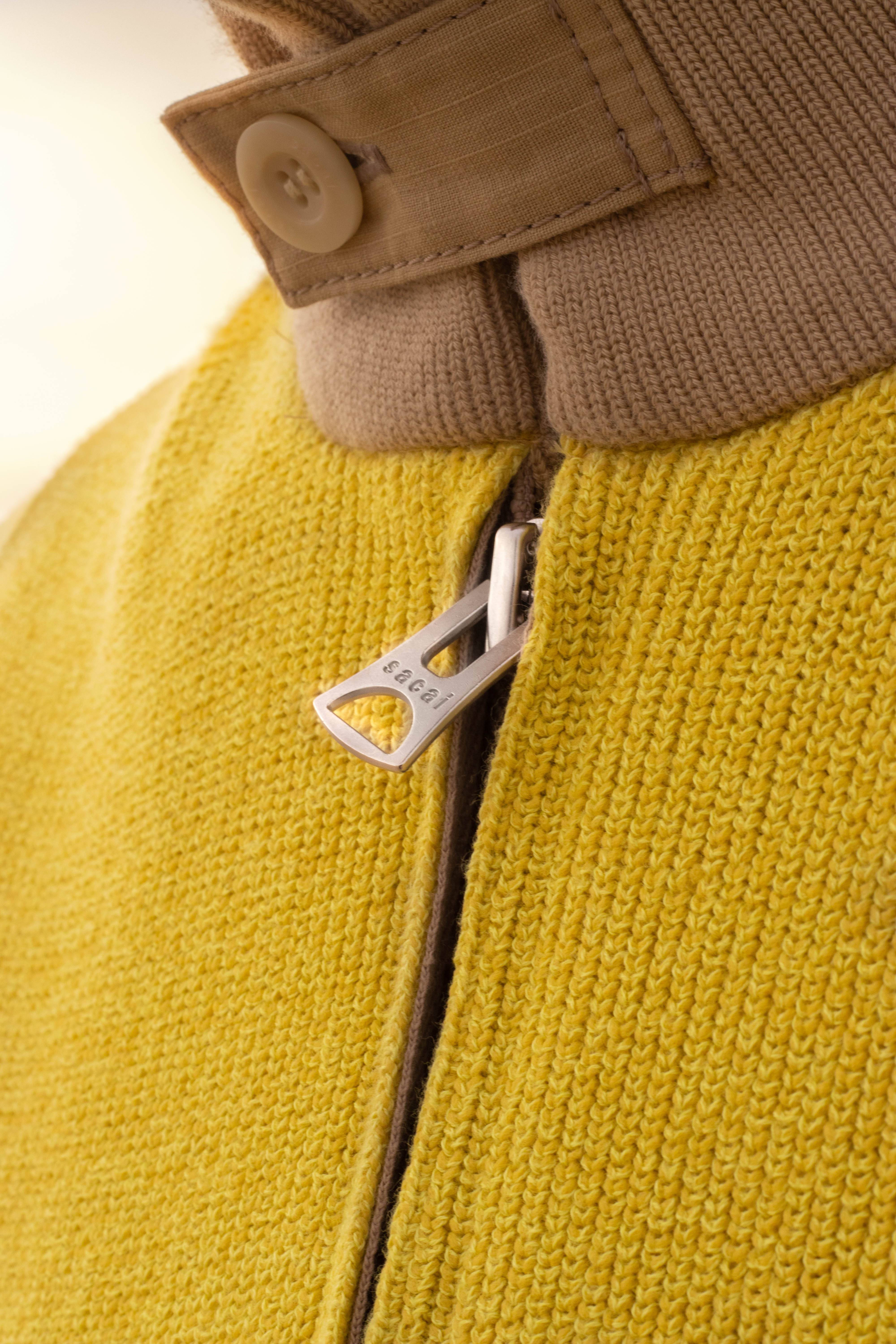 shooting masculin nature proche de l'océan, une tenue jaune très vif qui contraste avec le blue de l'eau
