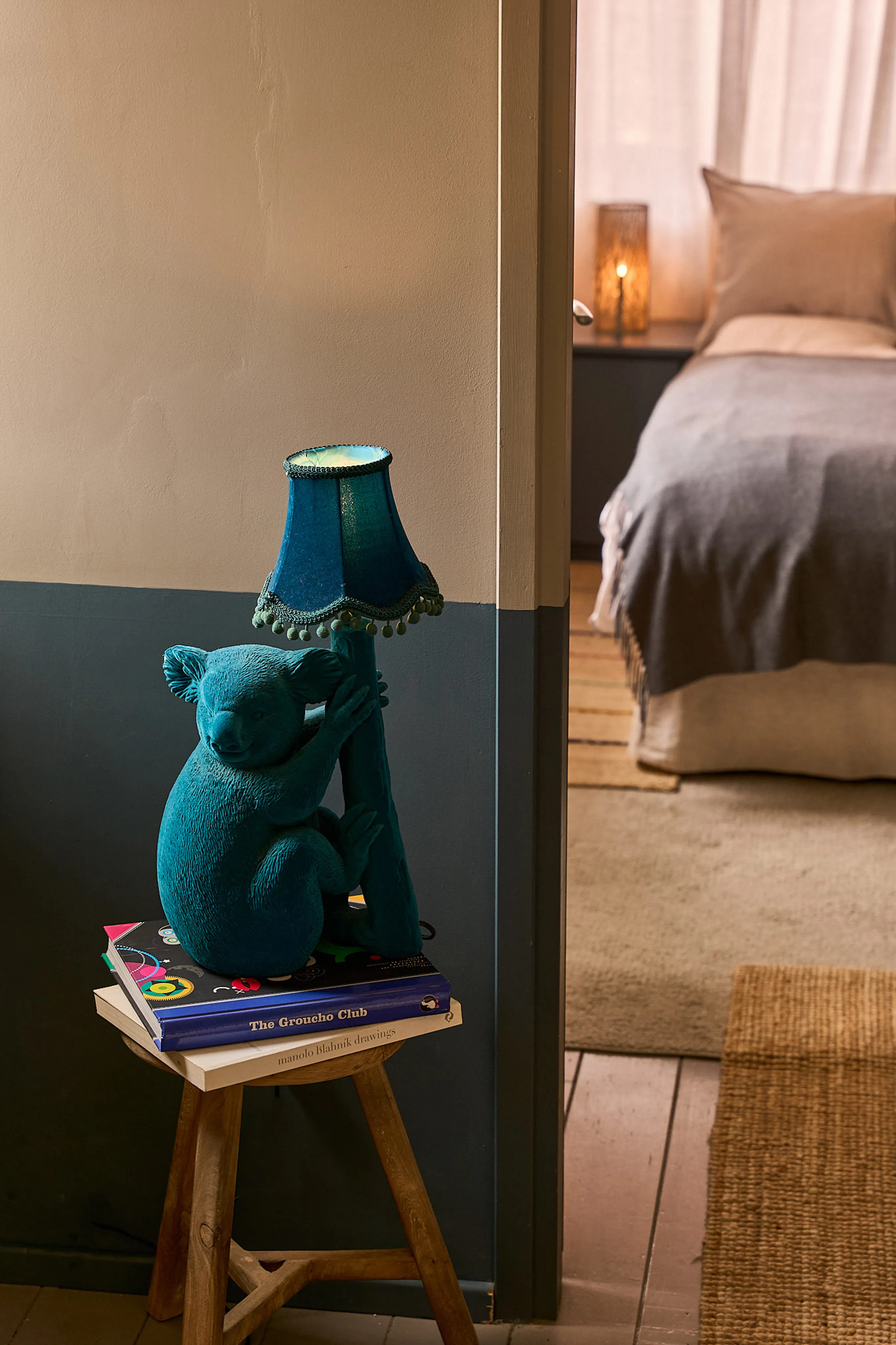 Teal koala lamp on a wooden stool with art books, Silvija Suite detail, Hidden House Stari Grad