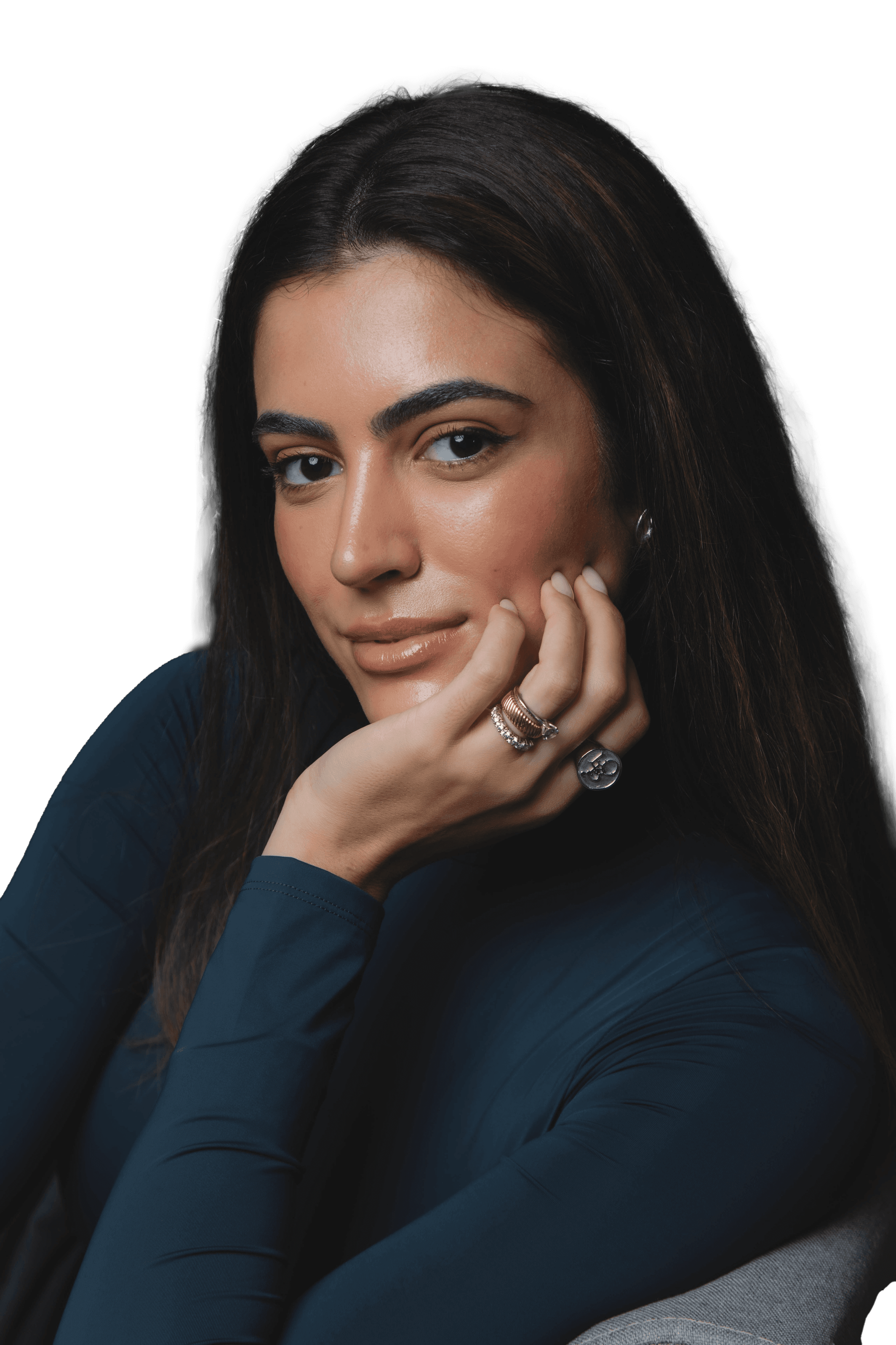 A woman sits cross-legged with eyes closed, wearing a white blouse and a long purple skirt, looking serene.