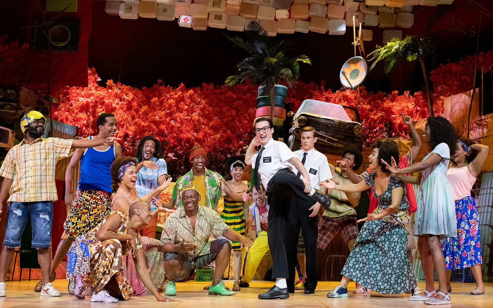 Performers on stage in a vibrant scene from "The Book of Mormon" musical.