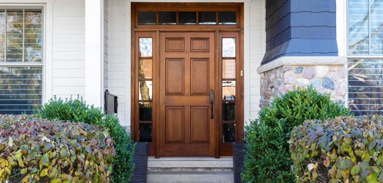 Entryway of a Calgary home with a wooden door, presenting a welcoming and traditional appearance.