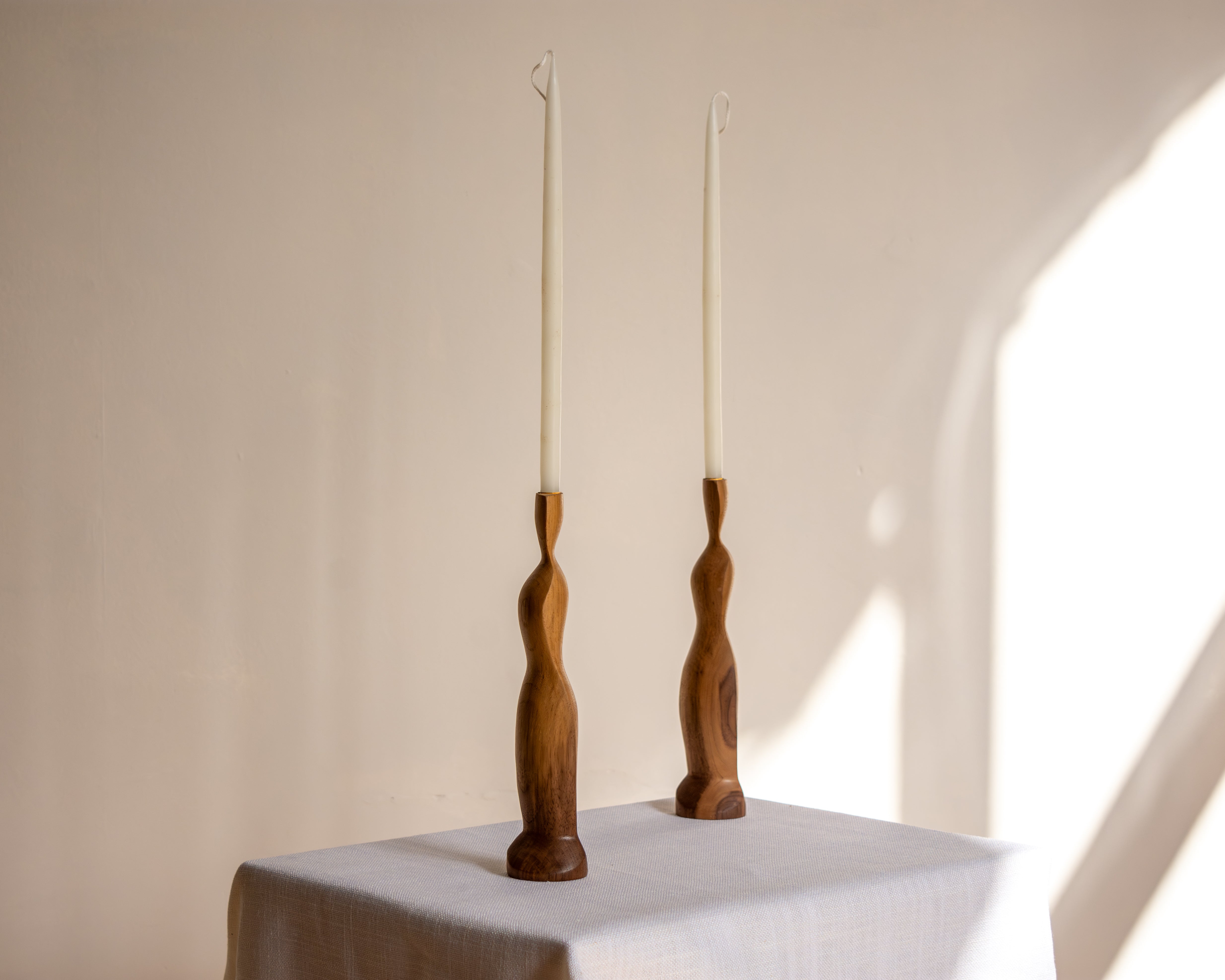 Two Figura Candlestick holders in Walnut on white background