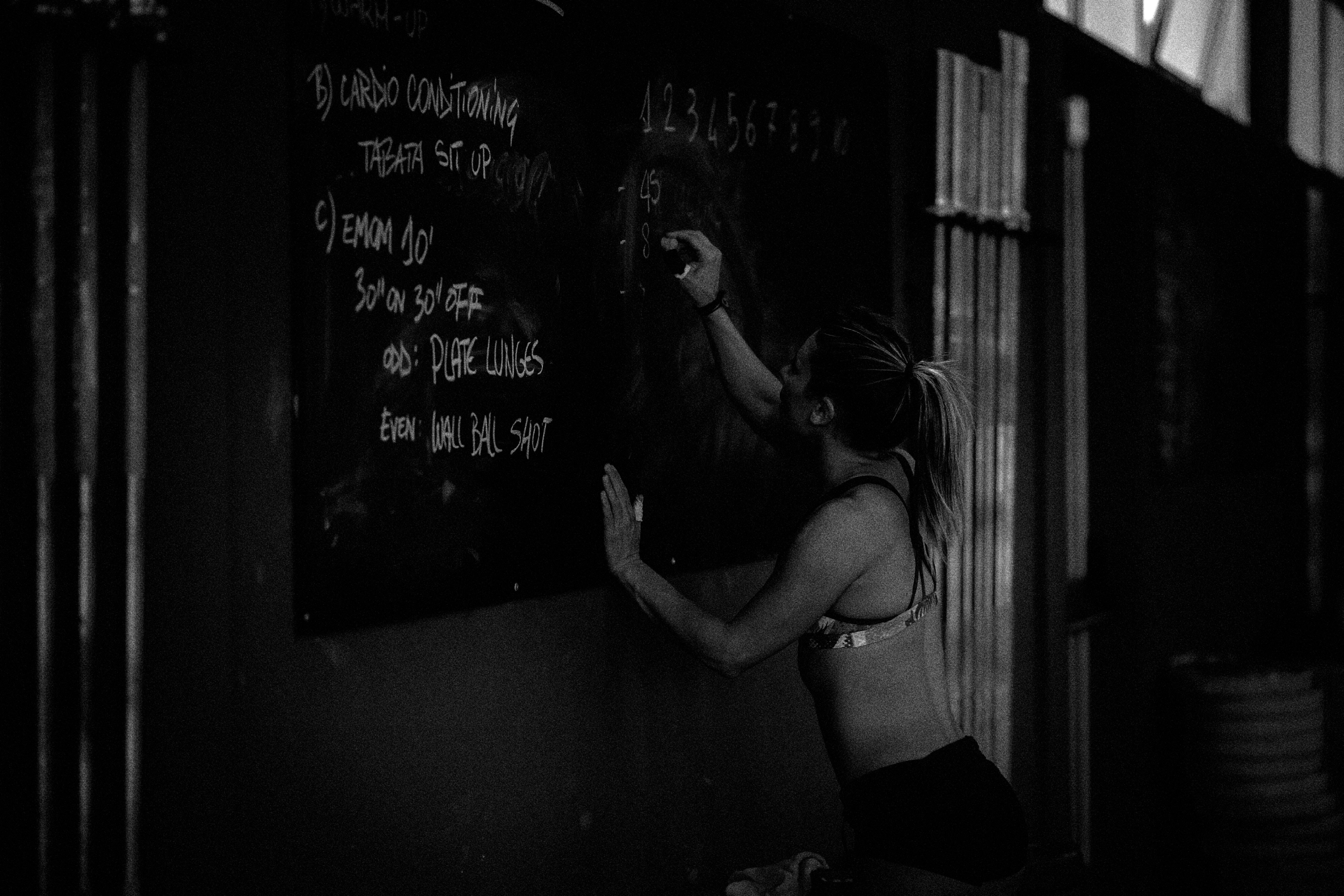 Athlete writing exercises on a chalkboard in a gym