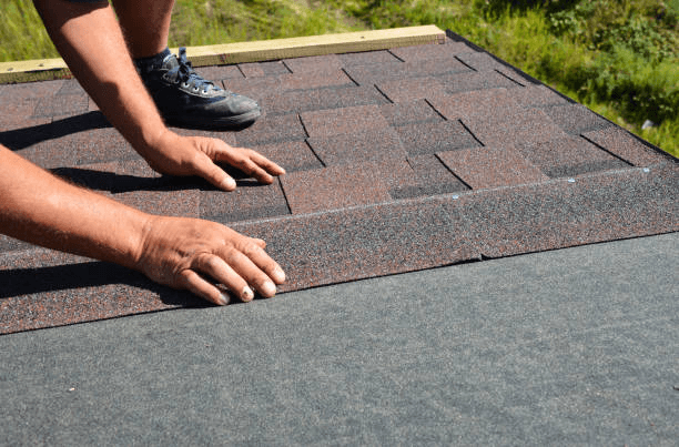 residential roofing services in Arlington, installing new shingles on a small backyard storage shed.