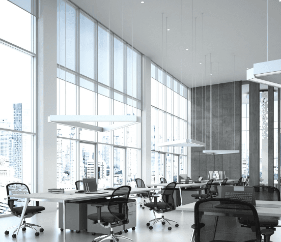 Modern glass building with illuminated interior and reflections at sunset