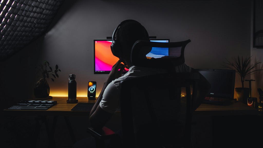 a person wearing headphones sitting in front of a computer