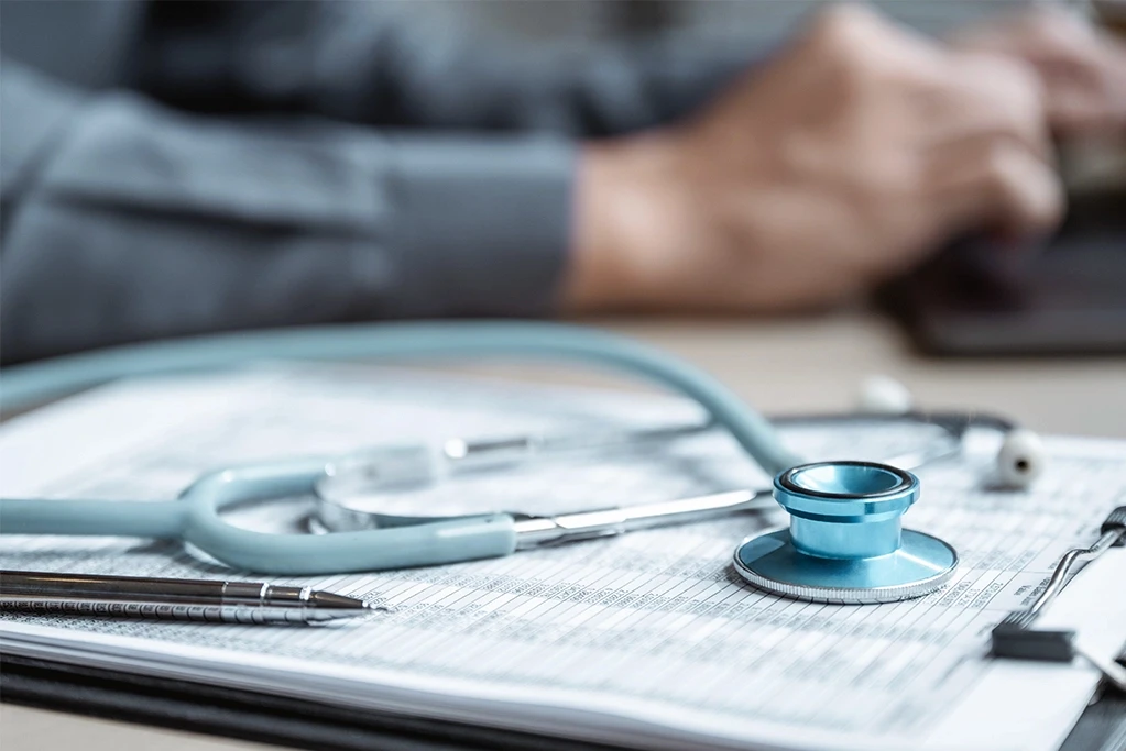 Stethoscope resting on a medical chart as a physician reviews records for a burn injury case