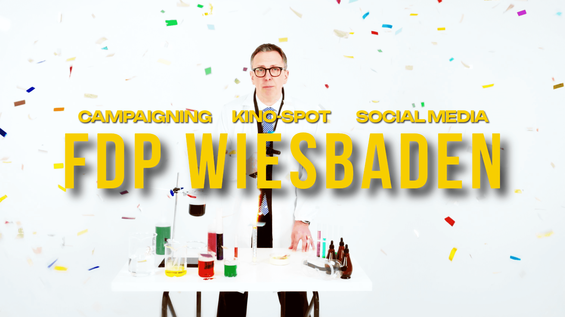 Confetti umhüllt Mann im Labor, Text: "FDP Wiesbaden".