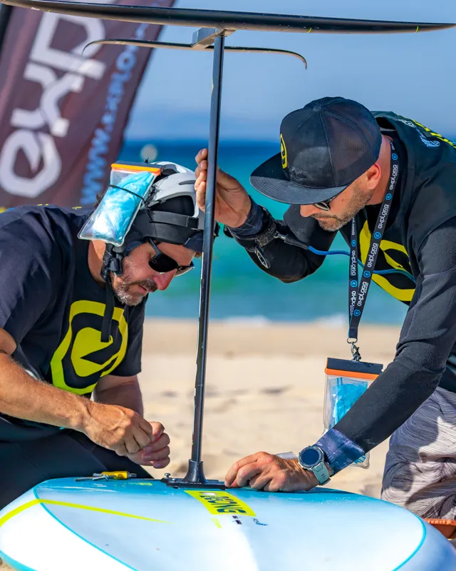 Explora Watersports Tarifa instructors assembling hydrofoil board before wing foiling session