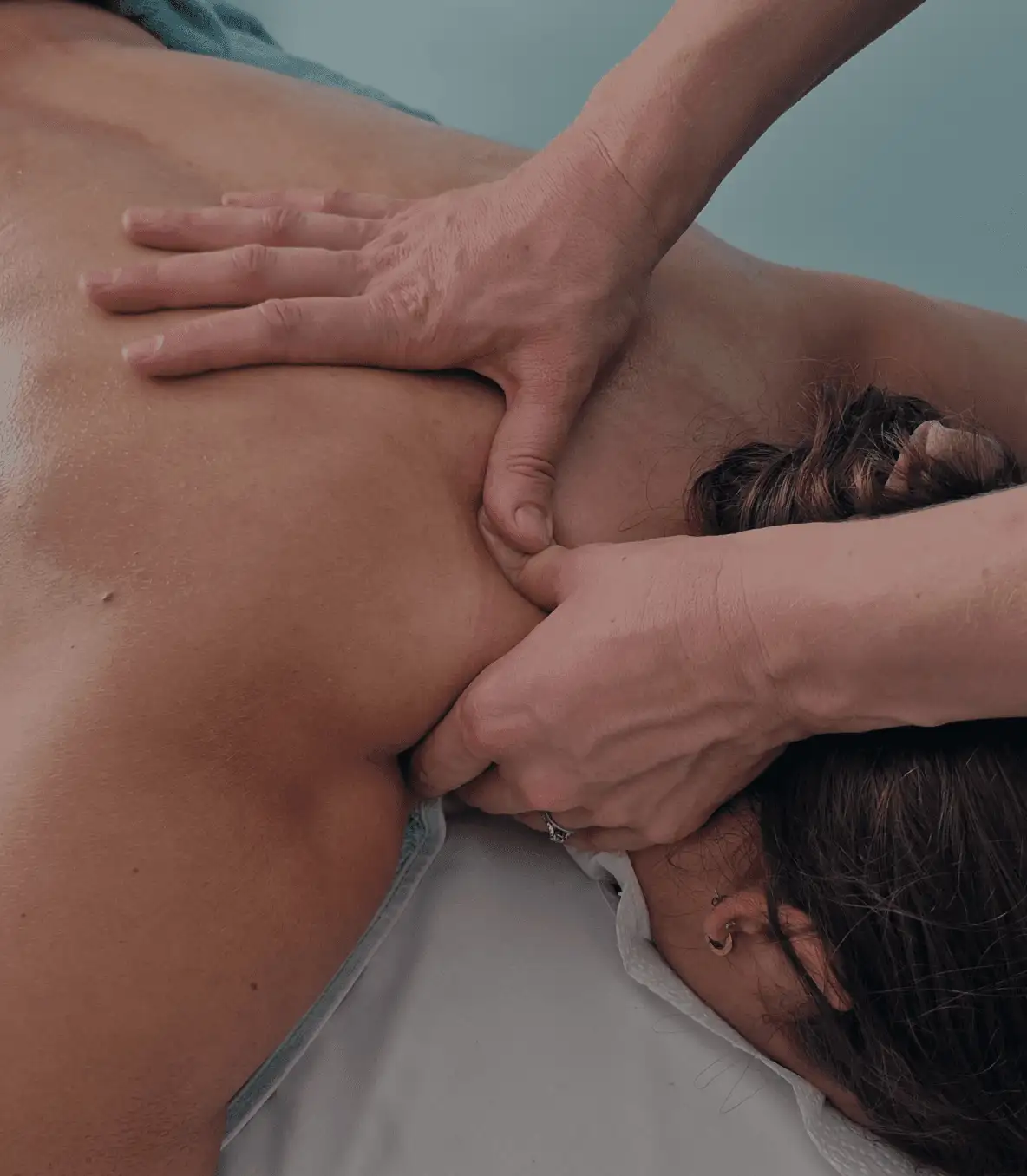A patient lying down receiving a spine mobilisation treatment to alleviate neck pain and reduce stiffness