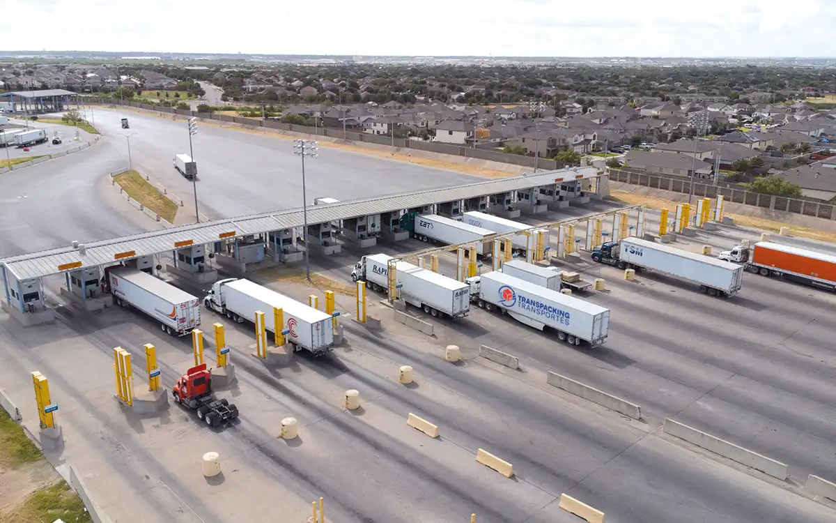 Camiones de Transpacking Transportes cruzando la frontera México-Texas en aduana internacional