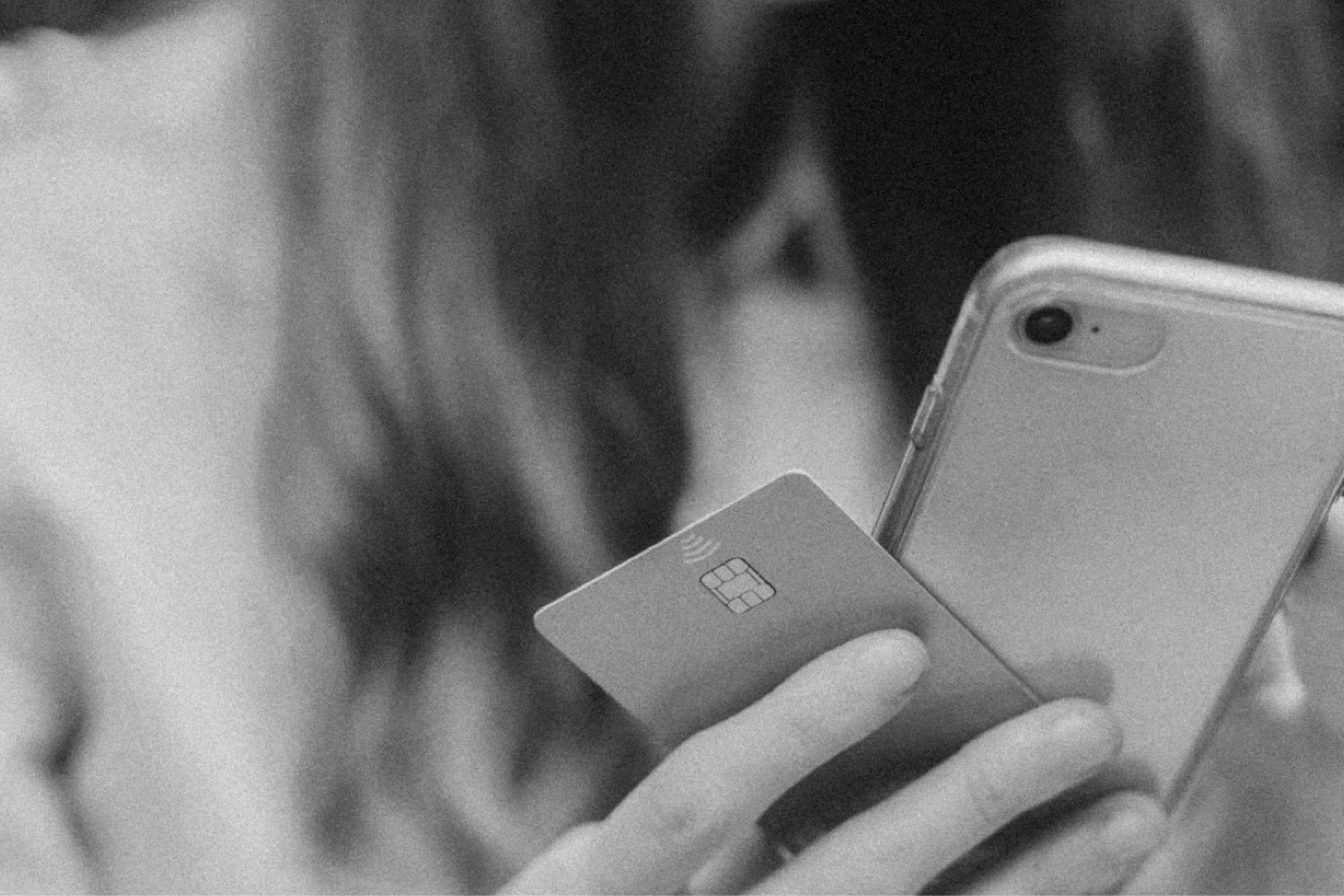 pessoa com celular em uma mão e cartão de crédito na outra. texto: total integration