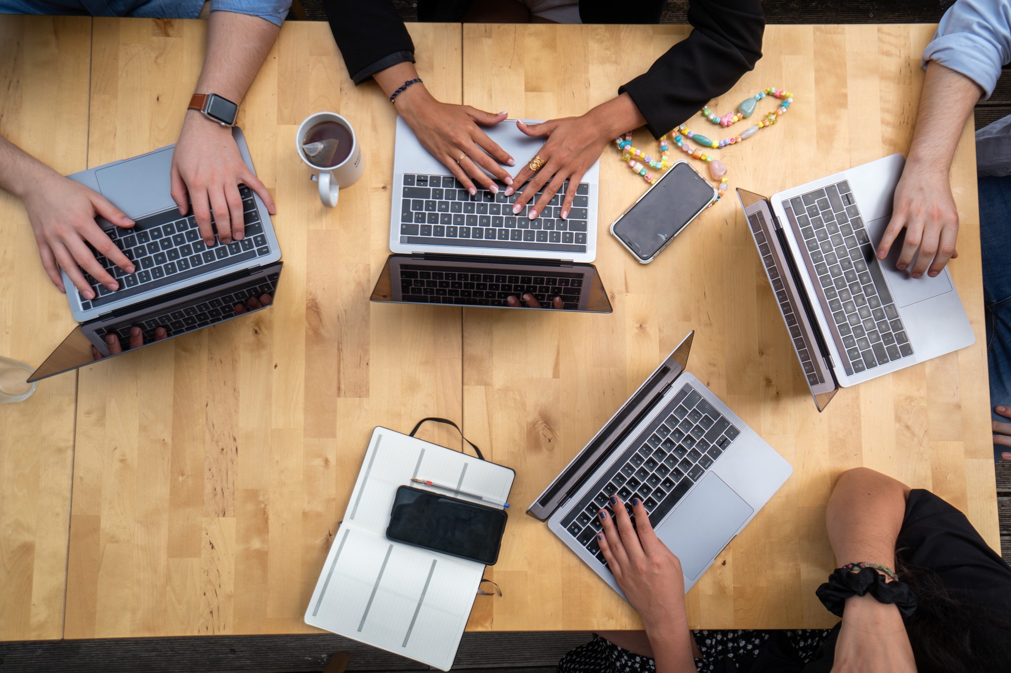 Image of people at a desk with their computers