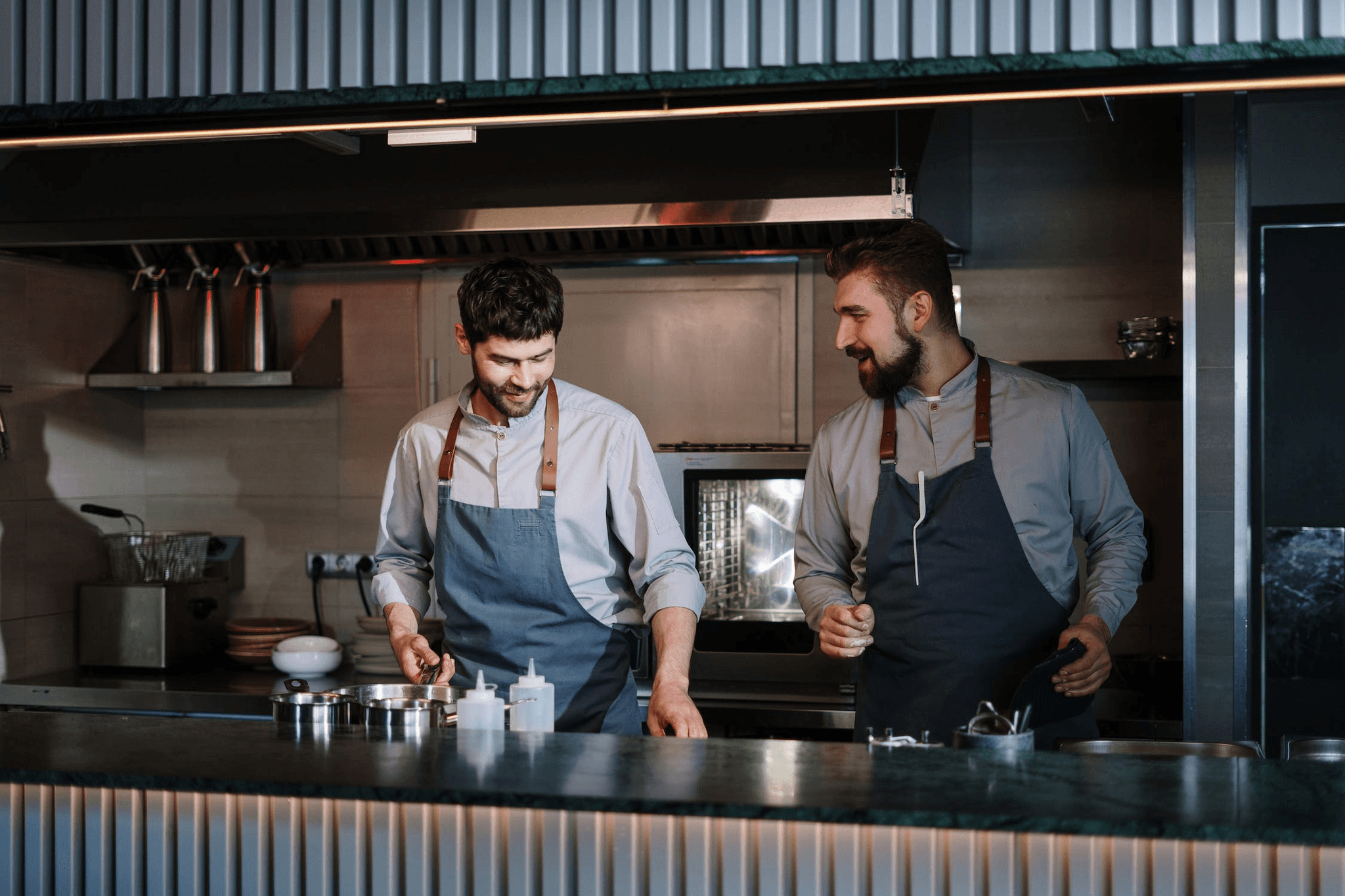 Two chefs behind the kitchen counter