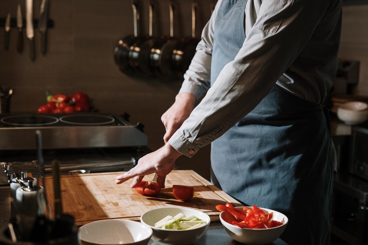 Chef cutting red bell peppers