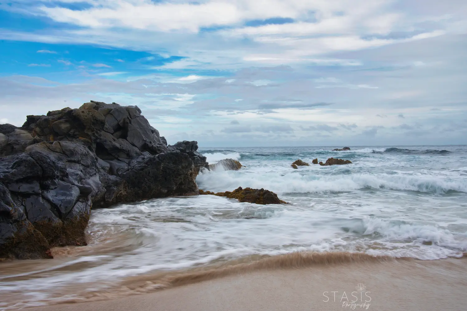 long exposure shot showing movement of waves crashing on the beach taken by professional traveling photographer