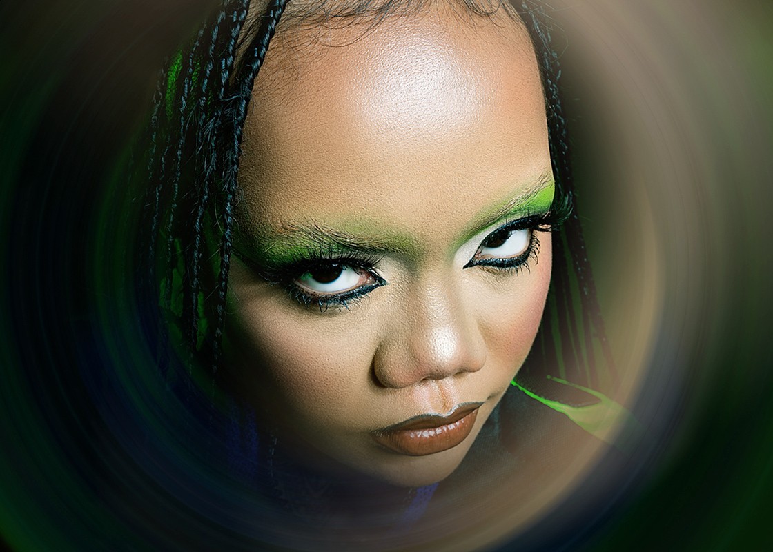 A frontal three-quarter image of an Asian lady with green and blue makeup on