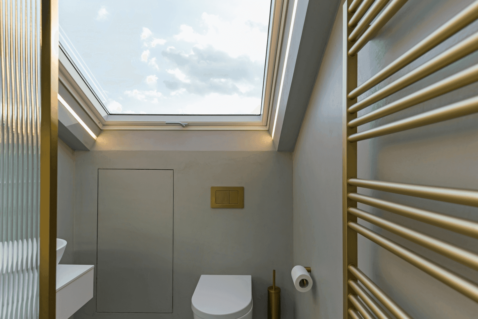 A South London bathroom with a skylight over the toilet.	