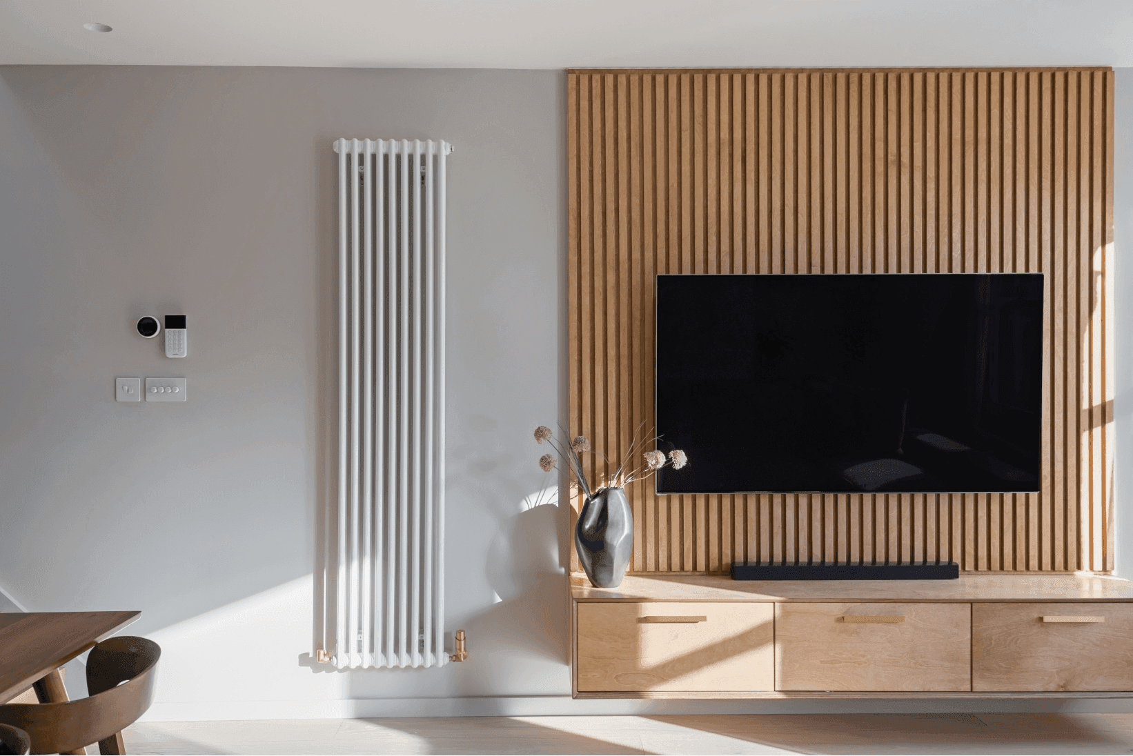 A modern loft living room with a TV and a radiator in South East London.	