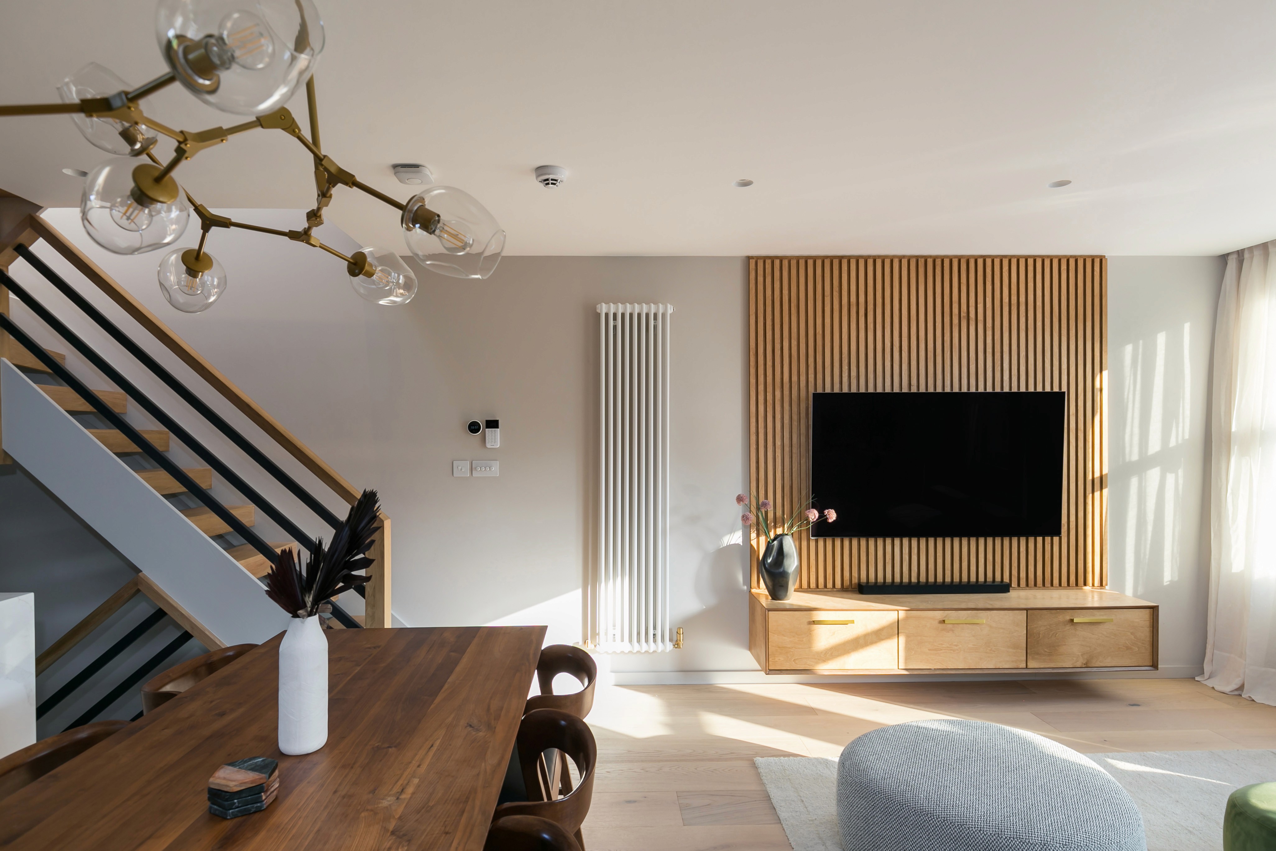 A modern loft living room with a TV and a radiator in South East London.	