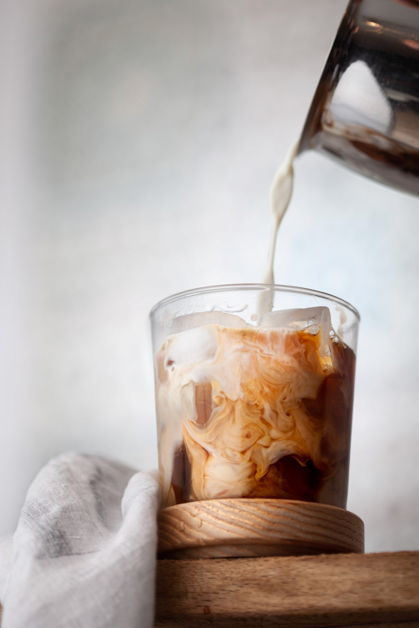 Image of milk being poured into a glass of coffee