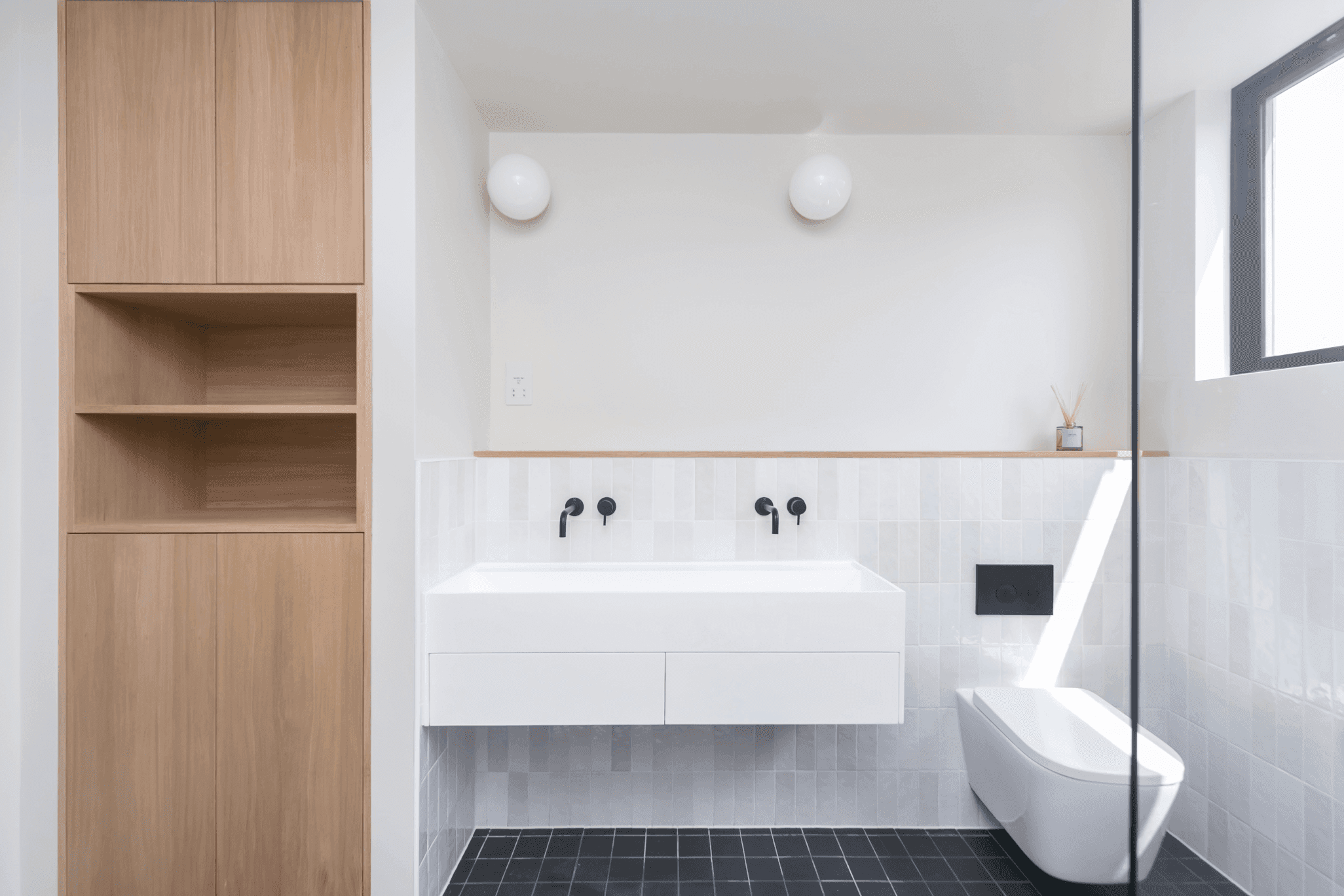 A loft conversion in South London featuring a bathroom with a sink, toilet, and shelves.