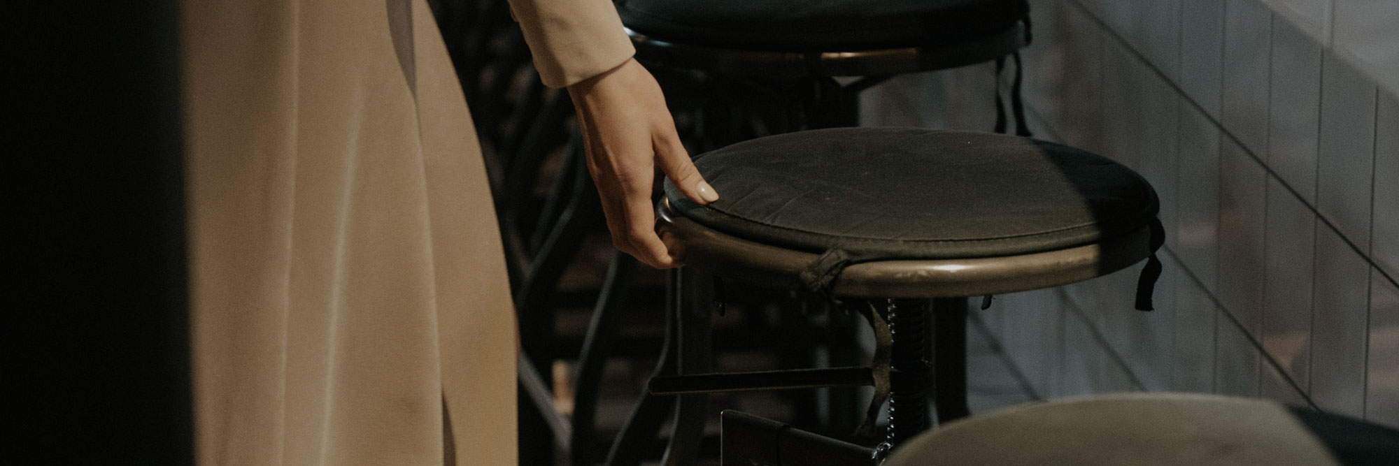 A woman pulling back a bar stool