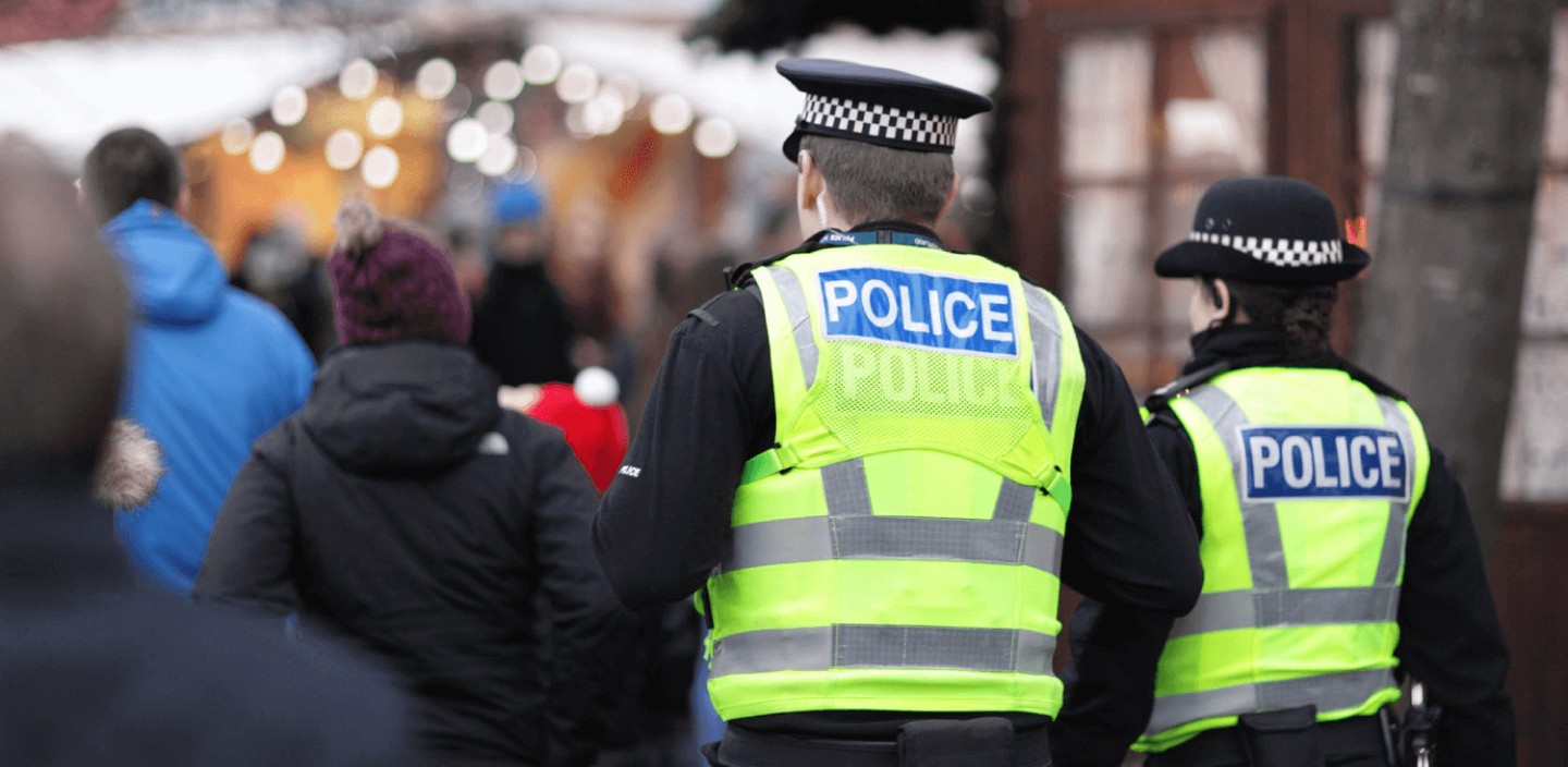 Two police officers walking through a busy crowd