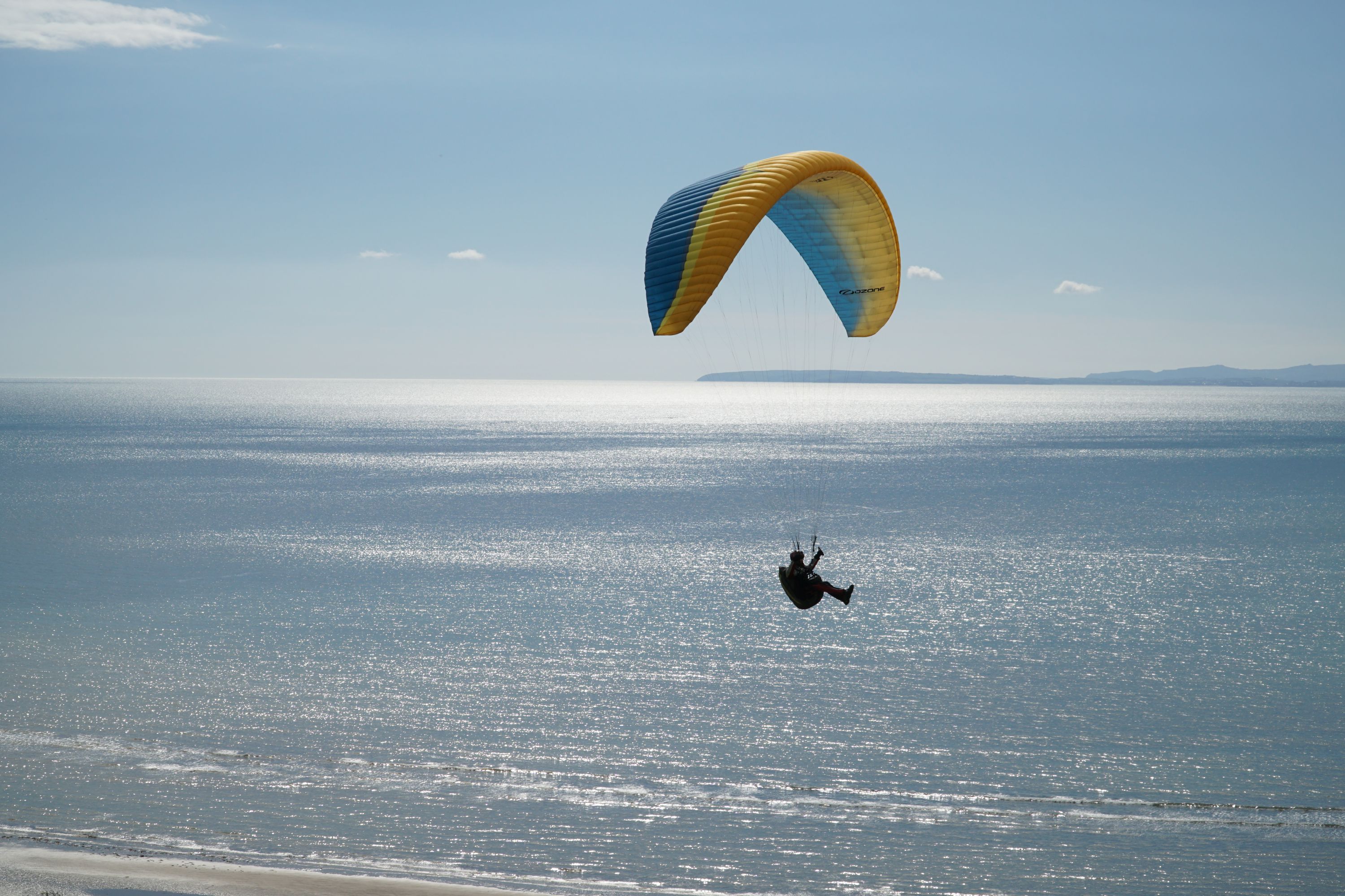 A photo og a paraglider over the coast of North Wales