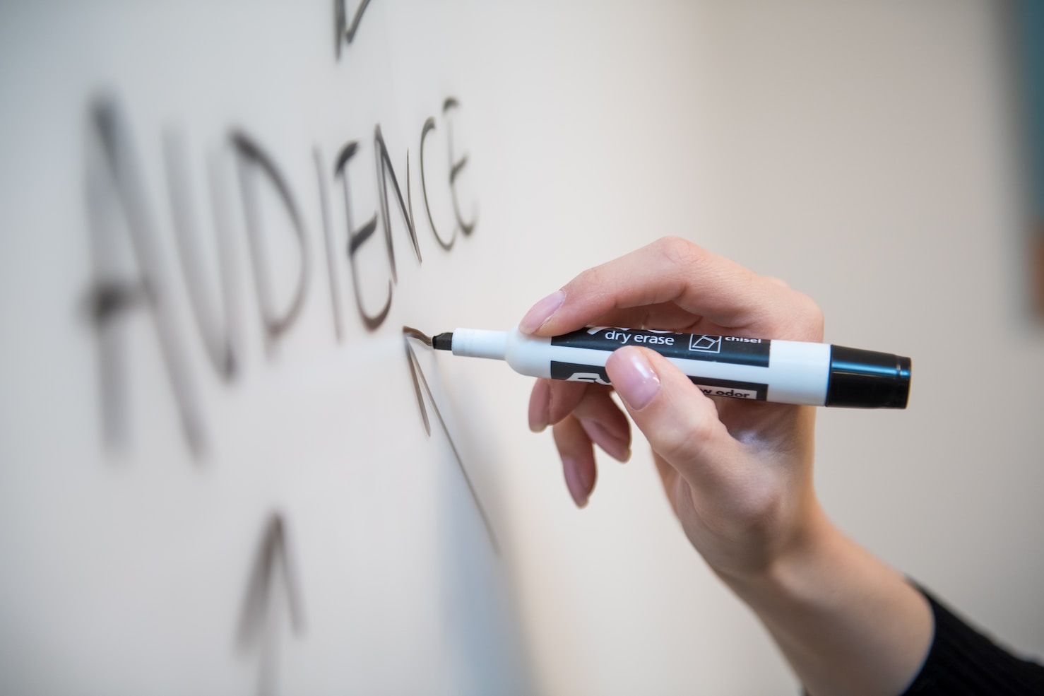 person writing audience on board