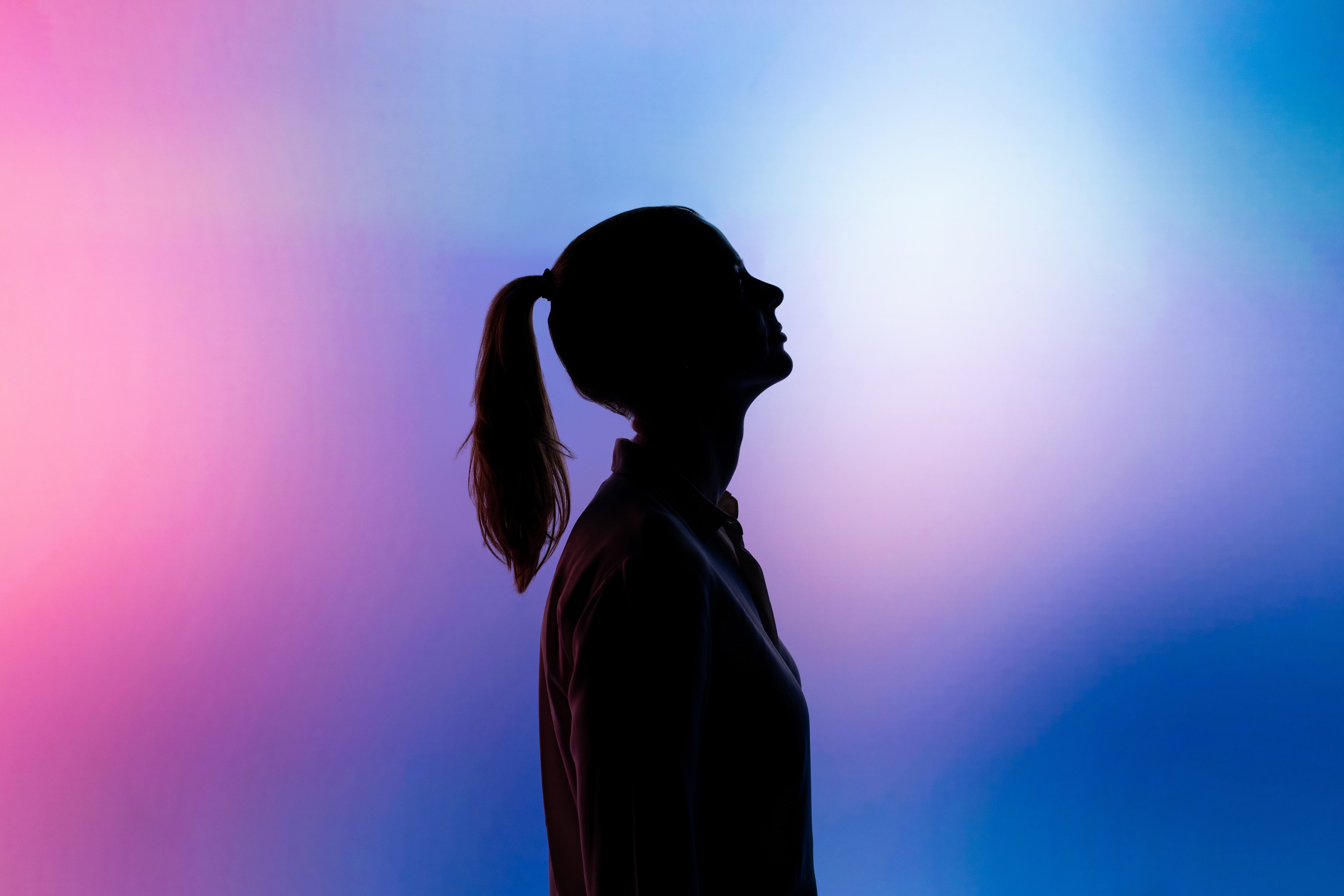 Silhouette of woman wearing black hat and black coat